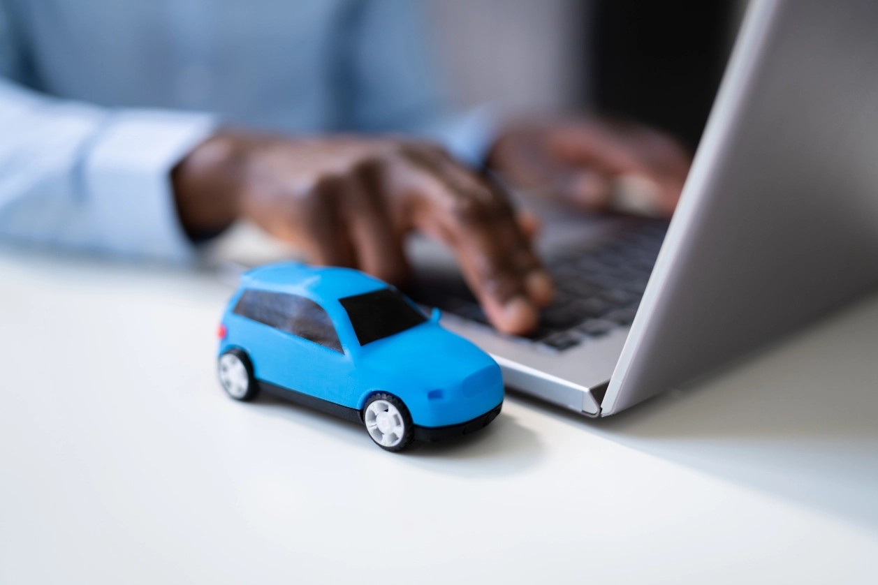 voiture miniature bleue avec ordinateur portable