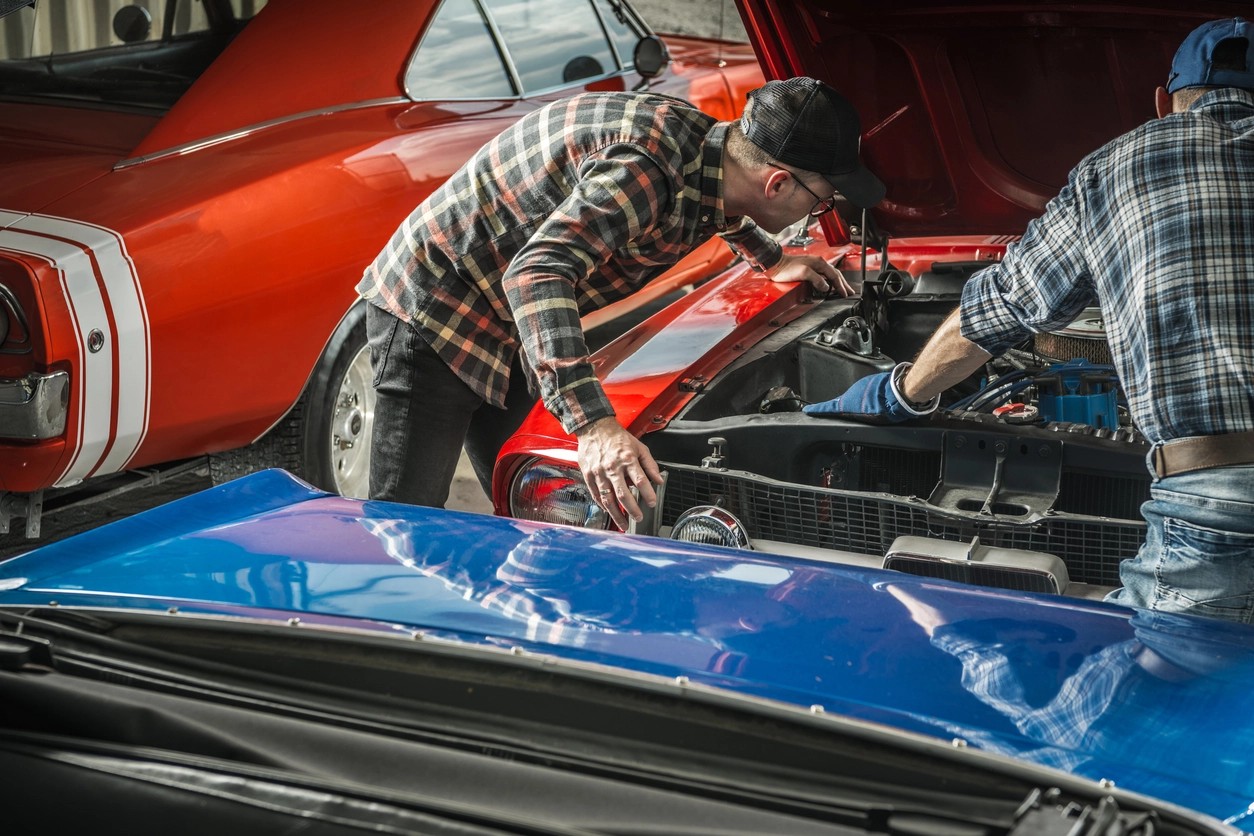 hommes regardant sous le capot de la voiture de collection 