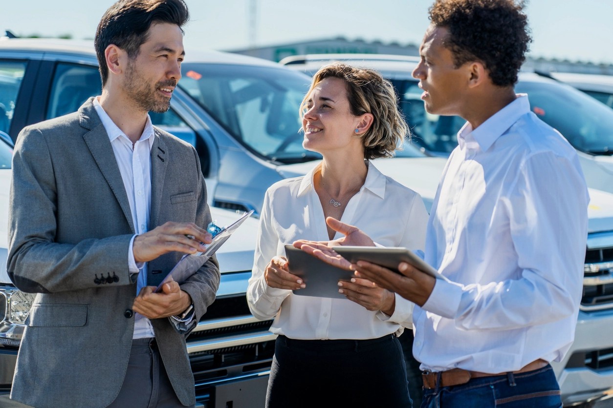 personnes au travail discutant des papiers de la voiture de société