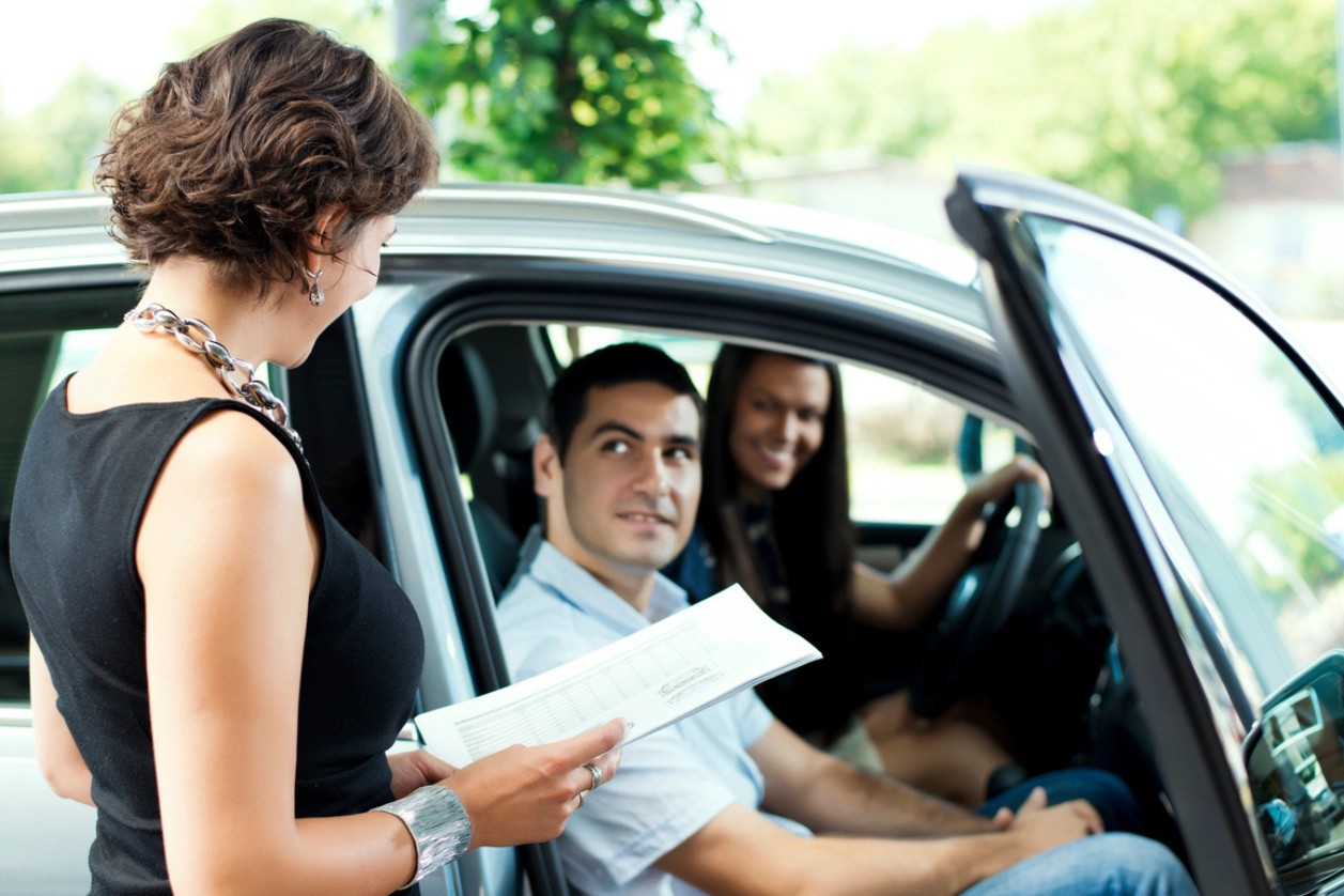 femme donnant les papiers de vente de la voiture de société 