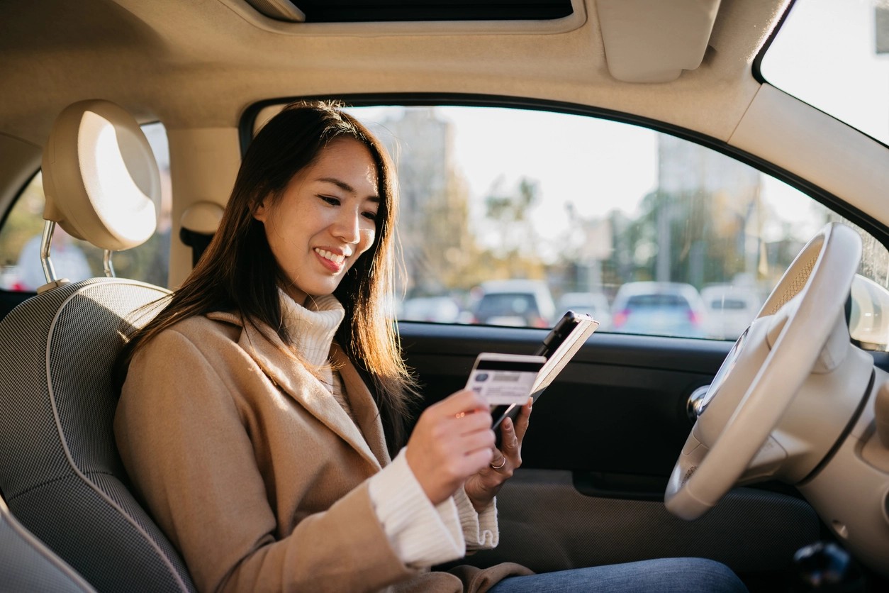 jeune femme payant la carte grise de sa nouvelle voiture en ligne 