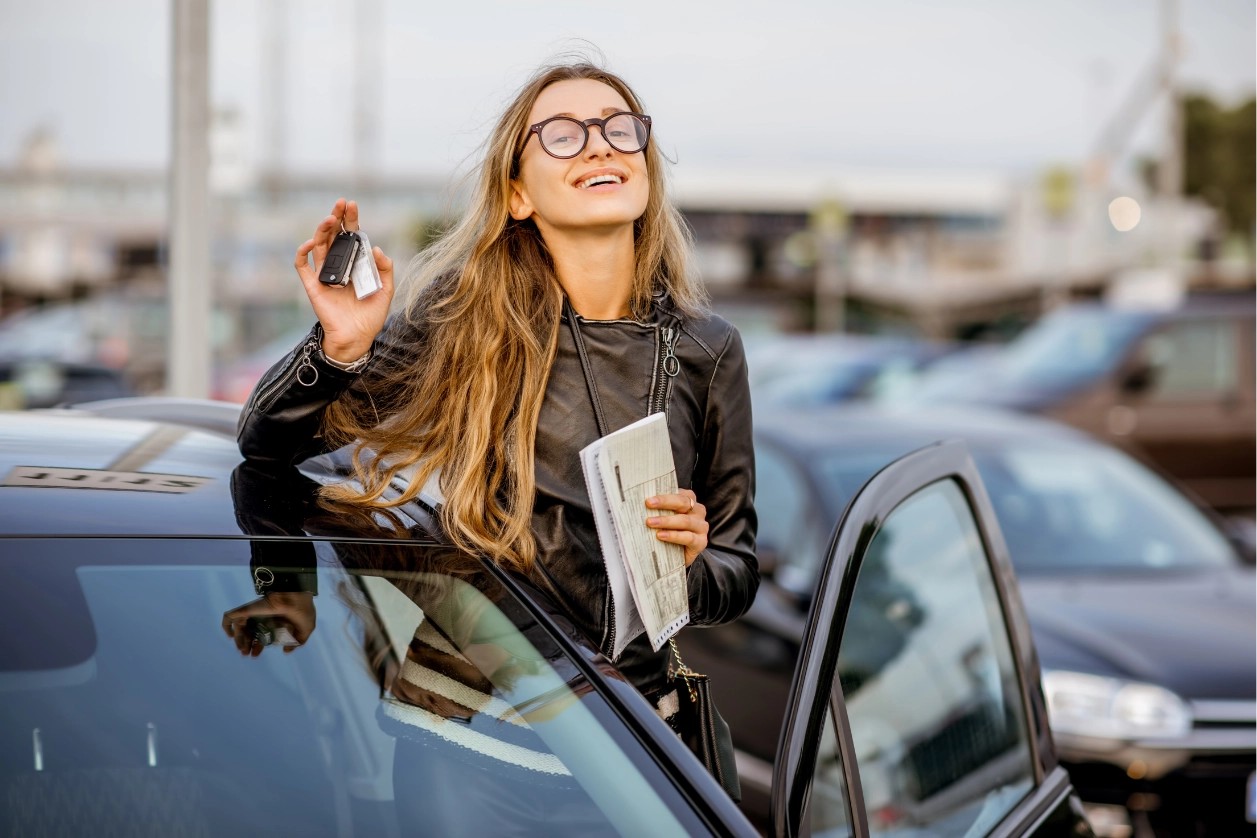 jeune femme à lunette tenant ses clés près de la voiture